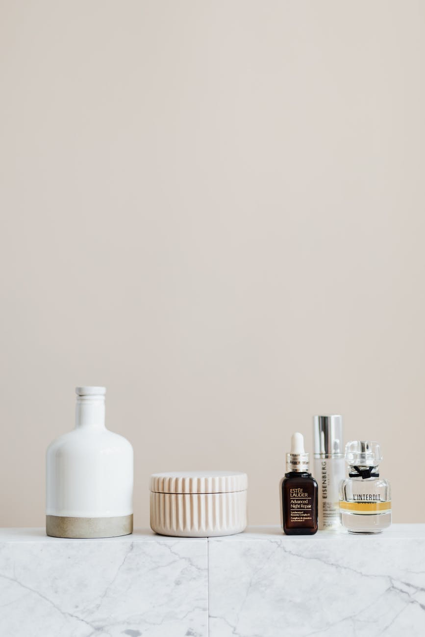 set of cosmetic supply on marble shelf in modern bathroom