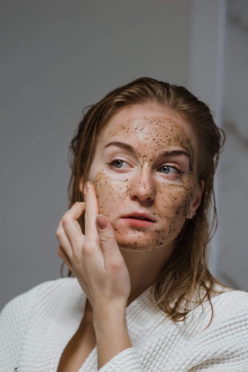 woman applying an anti aging coffee scrub on face
